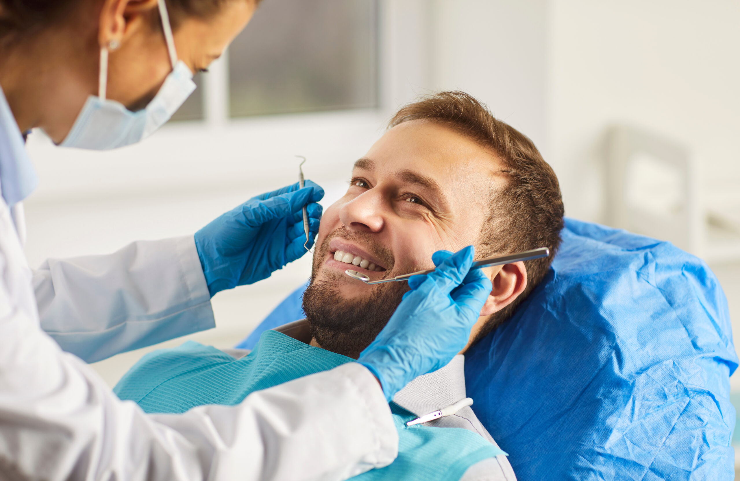 Man visiting dental for clinic oral health treatment, dentist exam, teeth, gums care for smiling healthy guy at doctor visit, demonstrating whitening teeth procedure result, satisfied with stomatology